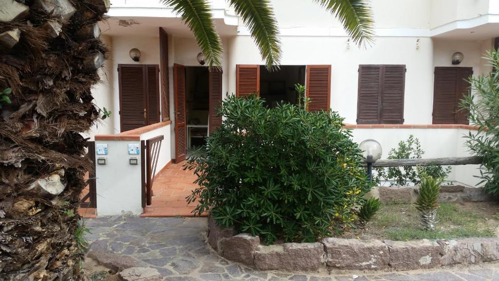 Casa blanca con persianas marrones y porche en ApartSea 26, en Calasetta