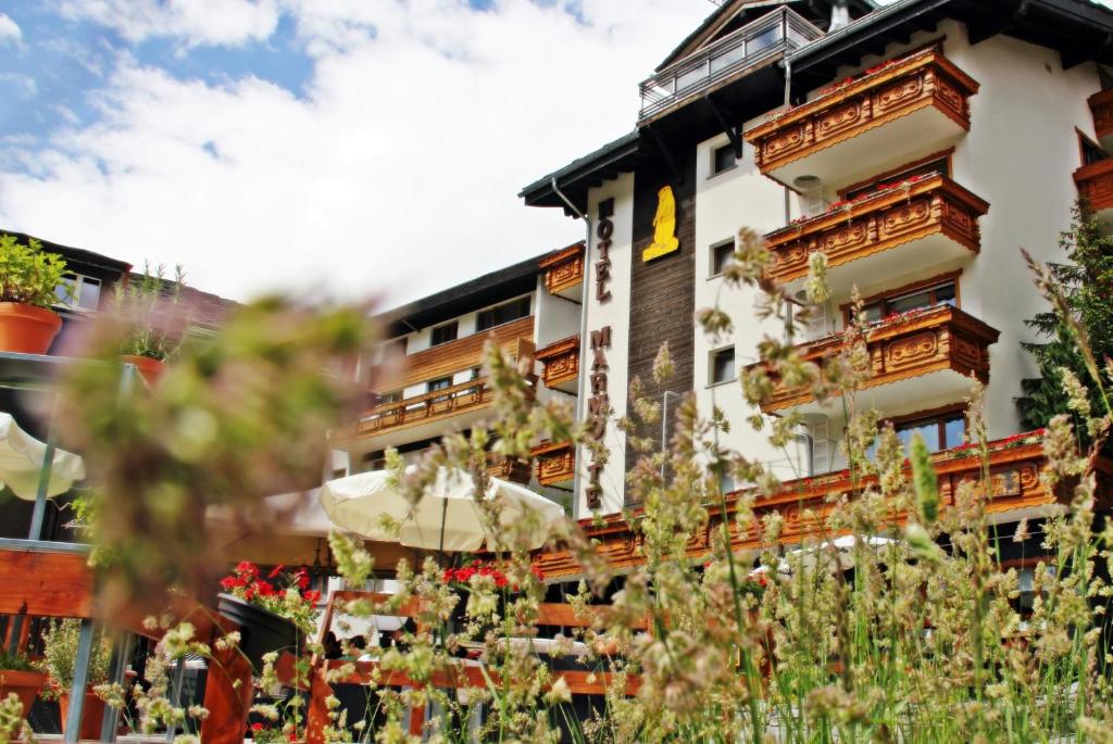 a building with an umbrella in front of it at Hotel Marmotte in Saas-Fee