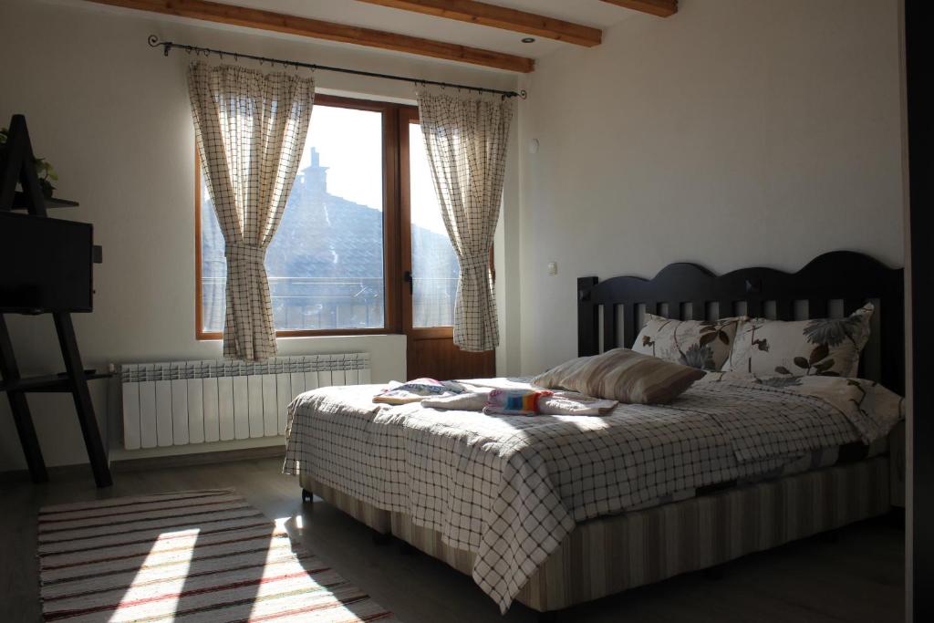 una camera da letto con un letto e una grande finestra di Стаи за гости Дима a Bansko