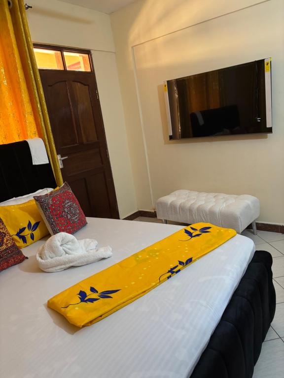 two beds in a room with yellow towels on them at Amtwapa 2bedroom apartment in Mtwapa