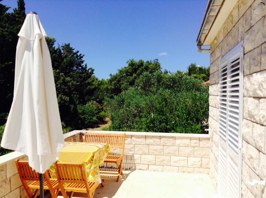 a patio with a table and a white umbrella at Guest house Perfect Location in Bol