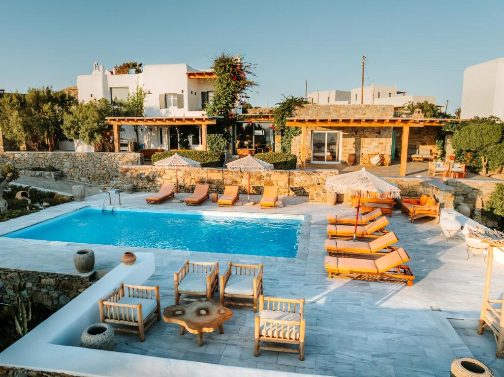 ein Resort mit Swimmingpool und Liegestühlen und ein Resort in der Unterkunft Villa Zina Sunset View St Lazaros 7 plus 1 Bedroom in Psarrou