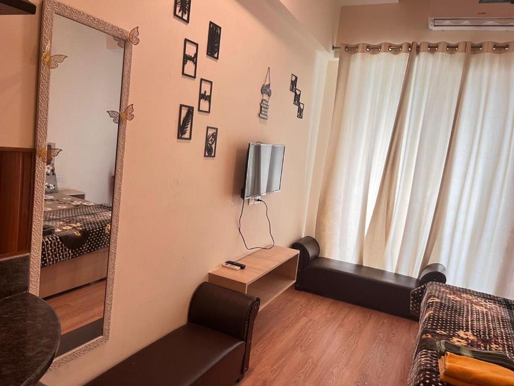 a living room with a mirror and a couch at Singh comfy studio in Ghaziabad