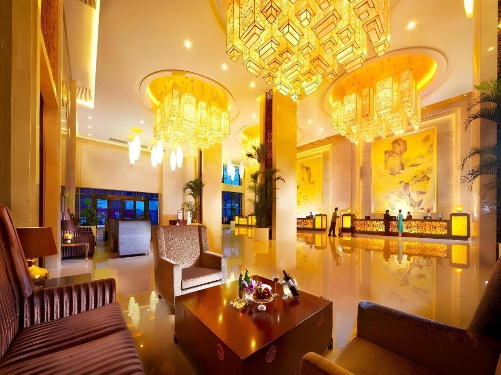 eine große Lobby mit Kronleuchtern und ein Wohnzimmer in der Unterkunft Gaosu New Century Hotel International Anhui in Hefei