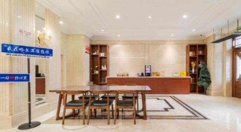 ein Esszimmer mit einem Tisch und einigen Stühlen in der Unterkunft Vienna Hotel Harbin Central Avenue in Harbin