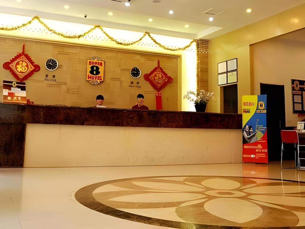 zwei Personen sitzen an einem Tresen in einer Hotellobby in der Unterkunft Super 8 Hotel Xi'an Dayan Tower Heping Gate Metro Station in Xi'an