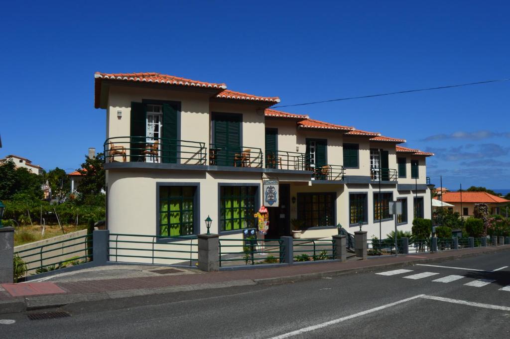 a large white building with a balcony on a street at Estalagem Corte do Norte in Ponta Delgada