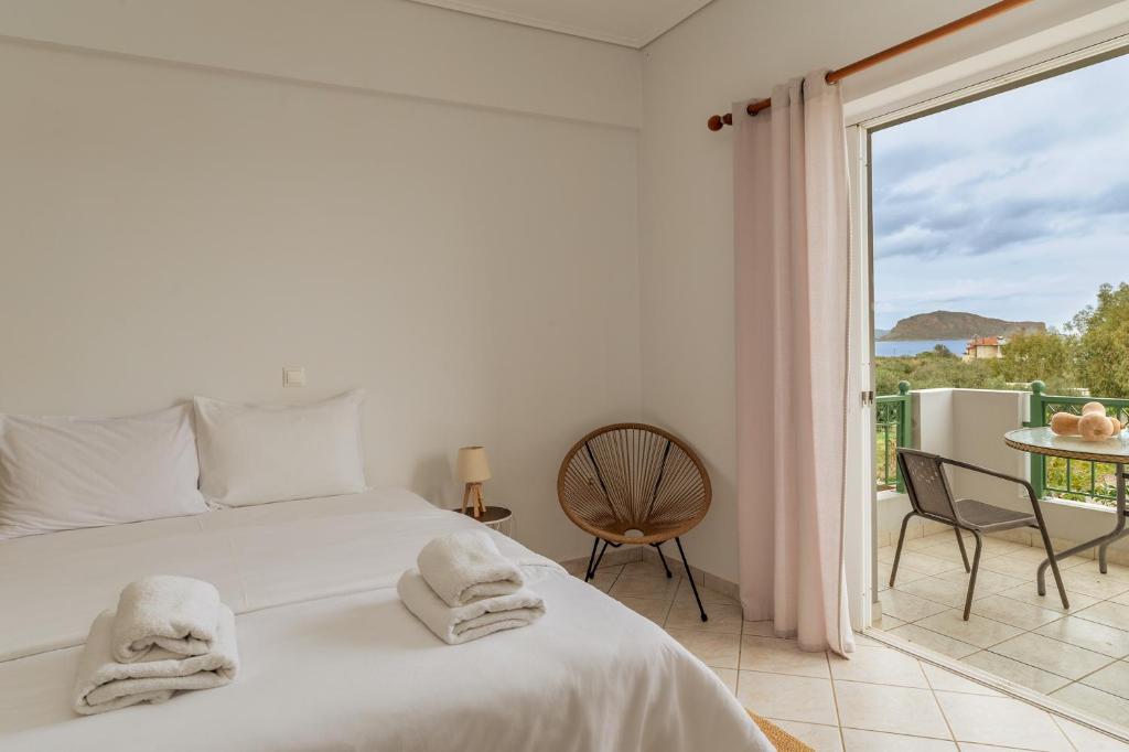 Un dormitorio blanco con una cama y un balcón. en Gregory's House, en Monemvasia