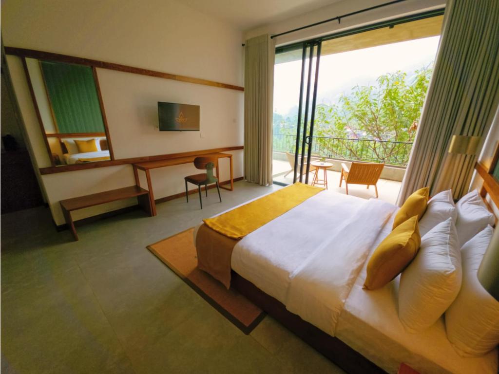 une chambre avec un lit, un bureau et une fenêtre dans l'établissement Te Dalu Resort & Spa, à Ella