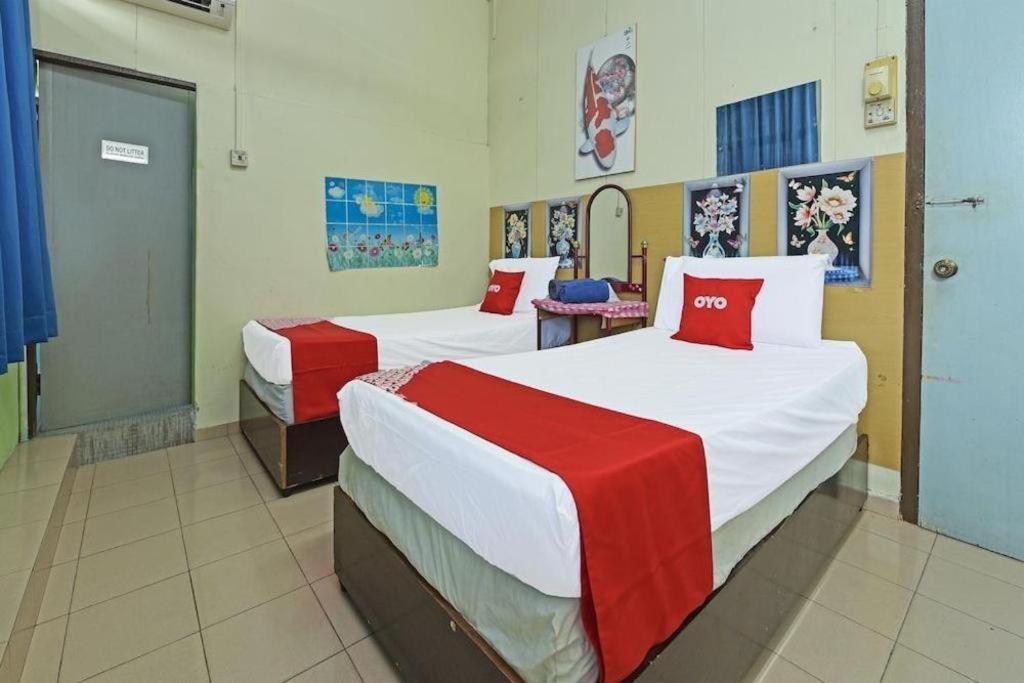 a bedroom with two beds with red and white sheets at SPOT ON 90625 Super Green Grass Hotel in Yong Peng