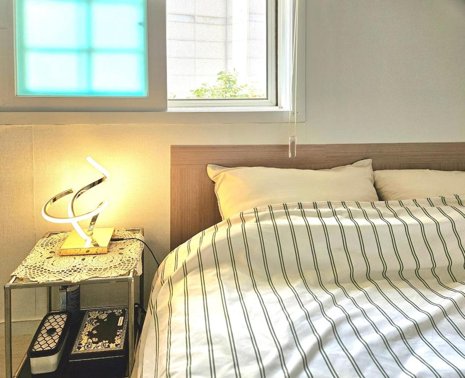 a bedroom with a bed and a table with a lamp at Namsan Nest in Seoul
