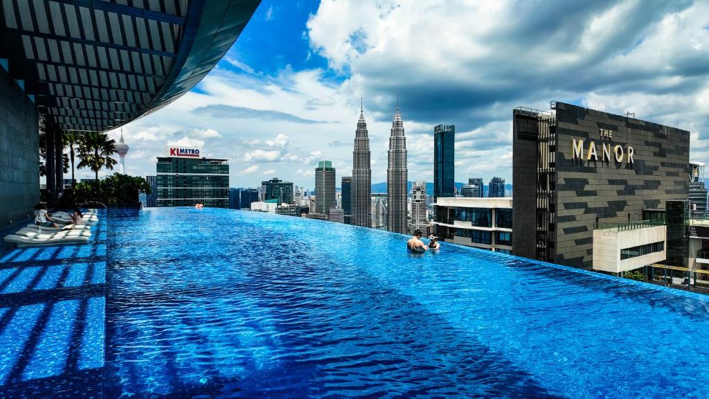 a swimming pool on top of a building with a city at Eaton Residence KLCC - J Home in Kuala Lumpur