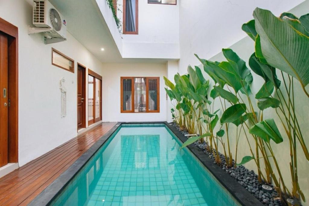 una piscina en una casa con plantas en Nice Villa In Seminyak #YoNa, en Seminyak