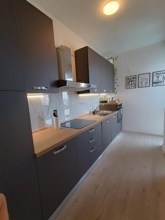 a kitchen with gray cabinets and wooden counter tops at Maison Cesare in Ravenna