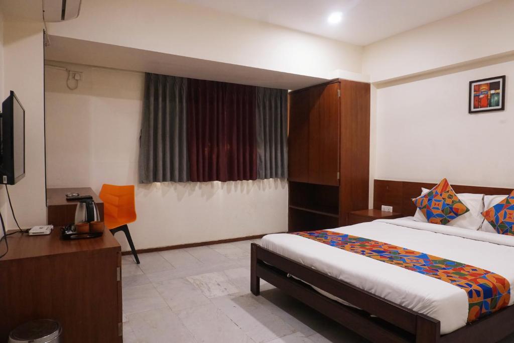 una habitación de hotel con una cama y un televisor en Executive Residency, en Pune