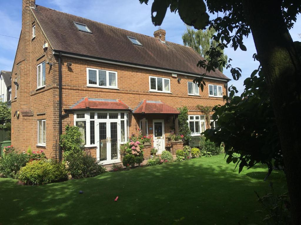 Una casa de ladrillo con césped delante. en Grove House Bed & Breakfast, en York