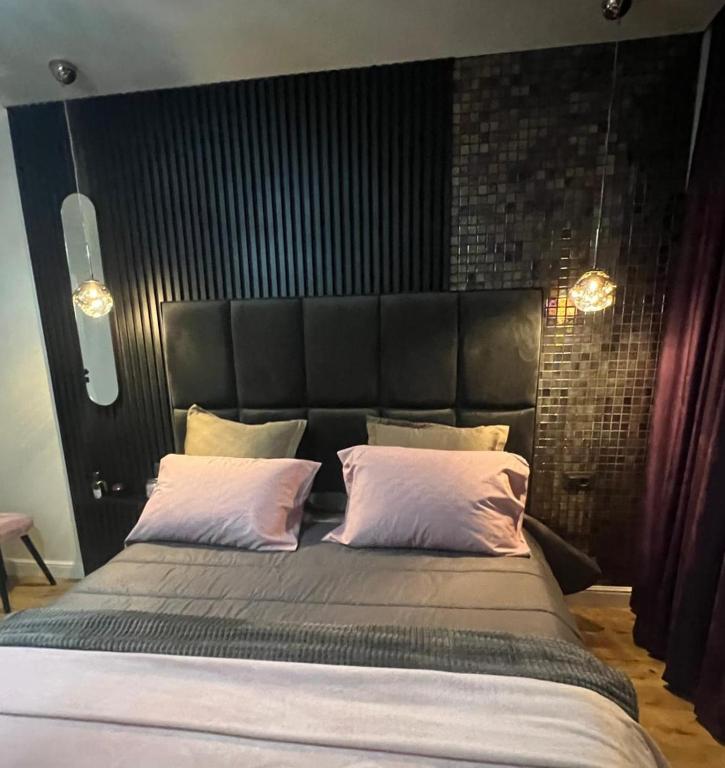 a bedroom with a large bed with a black headboard at GZP Residence Lugoj 16 in Lugoj