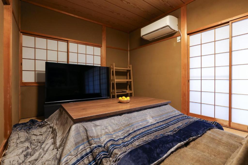 Habitación con cama grande y TV de pantalla plana. en 1日1組限定の貸切の民泊です 全館禁煙です 屋外喫煙所無し 間取りは2LDkです 2階部分だけを貸し出してます 1階は立ち入りできません 翌年の3月31日までコタツを設置しています, en Fukui