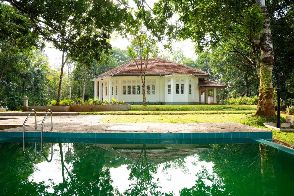 a house with a swimming pool in front of it at Evergreen Hideout by Tequila Holidays in Kandangama