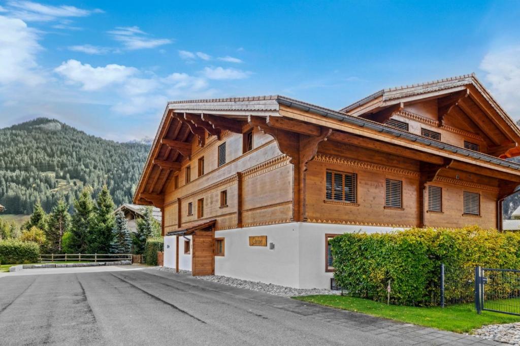 a large wooden building with a road in front at Charming Apartment in Gsteig in Gsteig