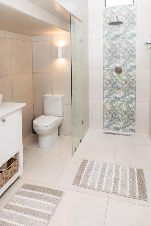 a bathroom with a toilet and a glass shower at Studio 51 in Port Alfred