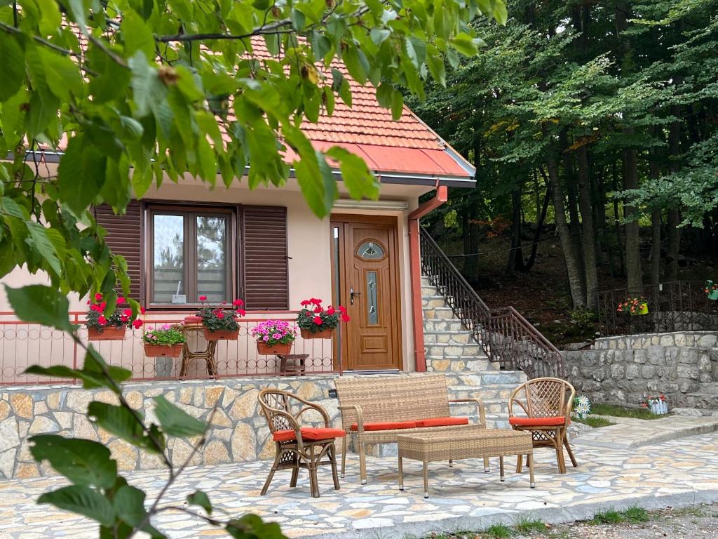 a small house with a table and chairs in front of it at Vikendica Silenzio in Cetinje