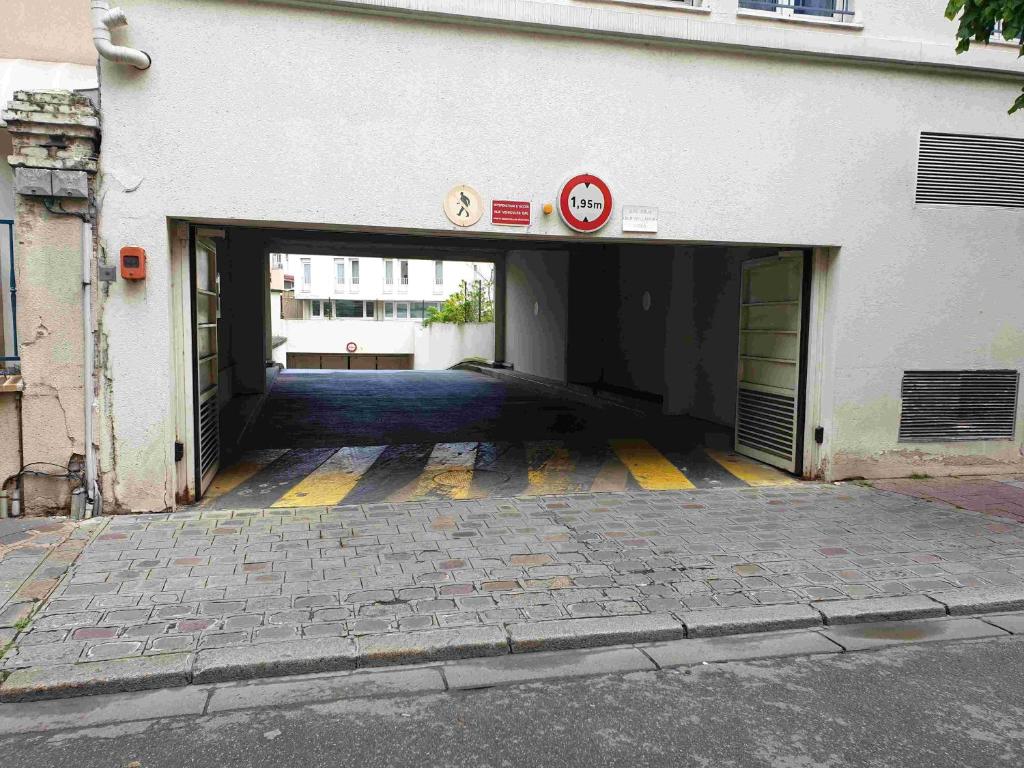 an open garage with a building with at Studio moderne à 15mn de la Défense in La Garenne-Colombes