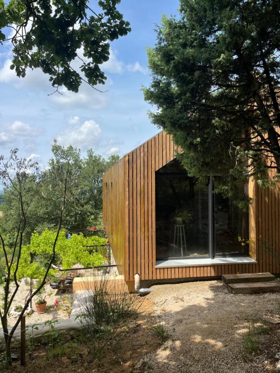 ein kleines Holzhaus mit einem großen Fenster in der Unterkunft Le Cigalou in Valaurie
