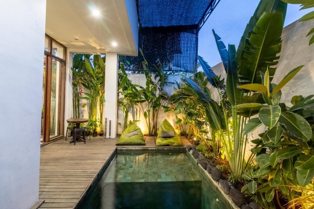 an indoor pool in a house with plants at Tiny Villa Bali Jimbaran in Jimbaran