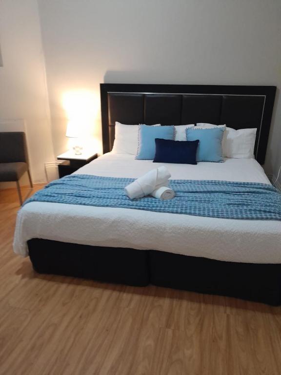 a bedroom with a large bed with blue and white pillows at Jerilderie Hotel - Pub, Restaurant & Accommodation in Jerilderie