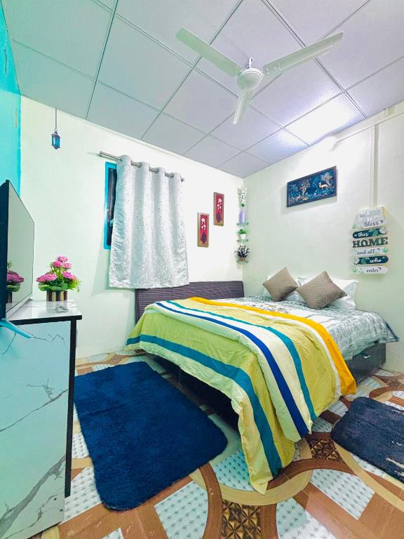 a bedroom with a bed with blue rugs and a ceiling at KKOZY NOOk in Aurangabad