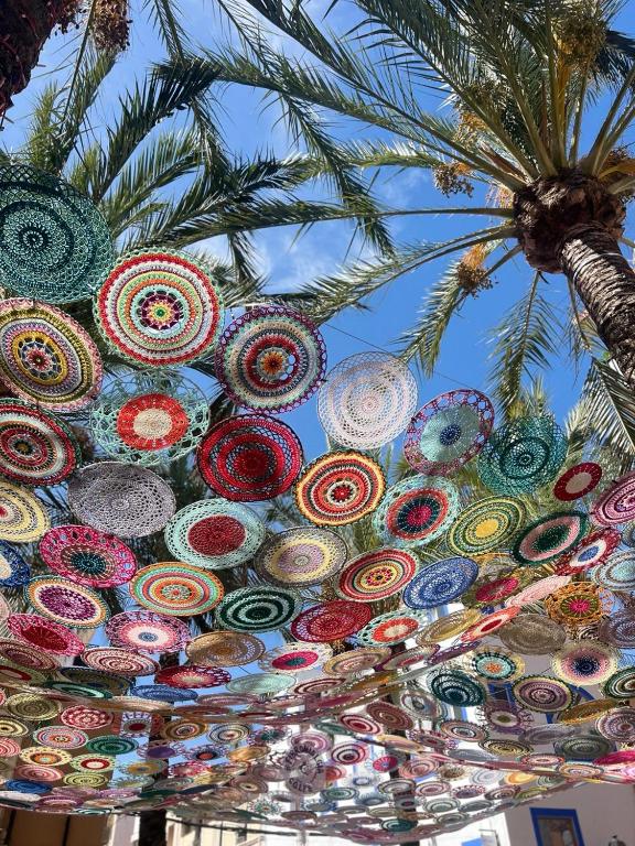 a bunch of colorful umbrellas hanging from a palm tree at Sol 3-Bedroom Apartments in Calpe