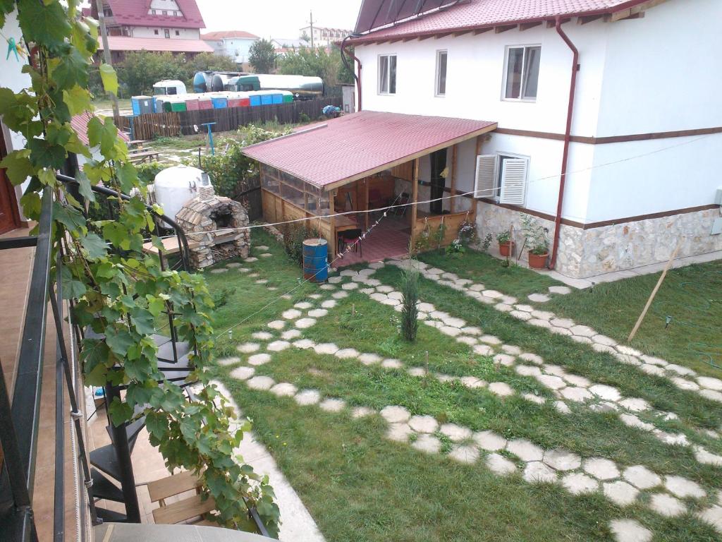 einen Hinterhof mit einem Haus und einem Garten mit Felsen in der Unterkunft Hesta in Vama Veche