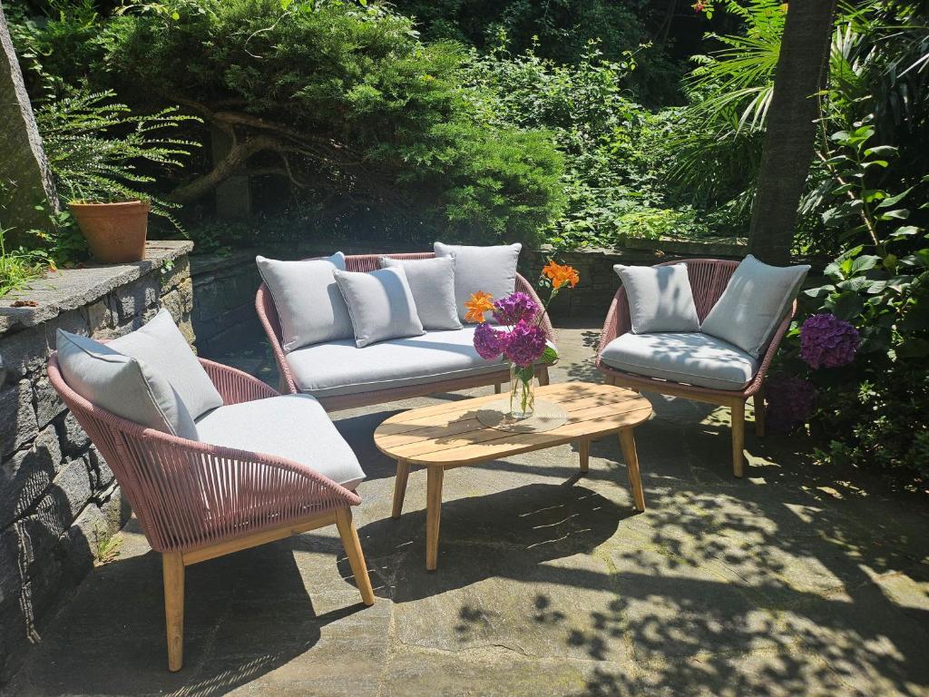 une terrasse avec 2 chaises et une table avec un canapé dans l'établissement Casa Colombina & Studio by Fewotessin, à Gordola
