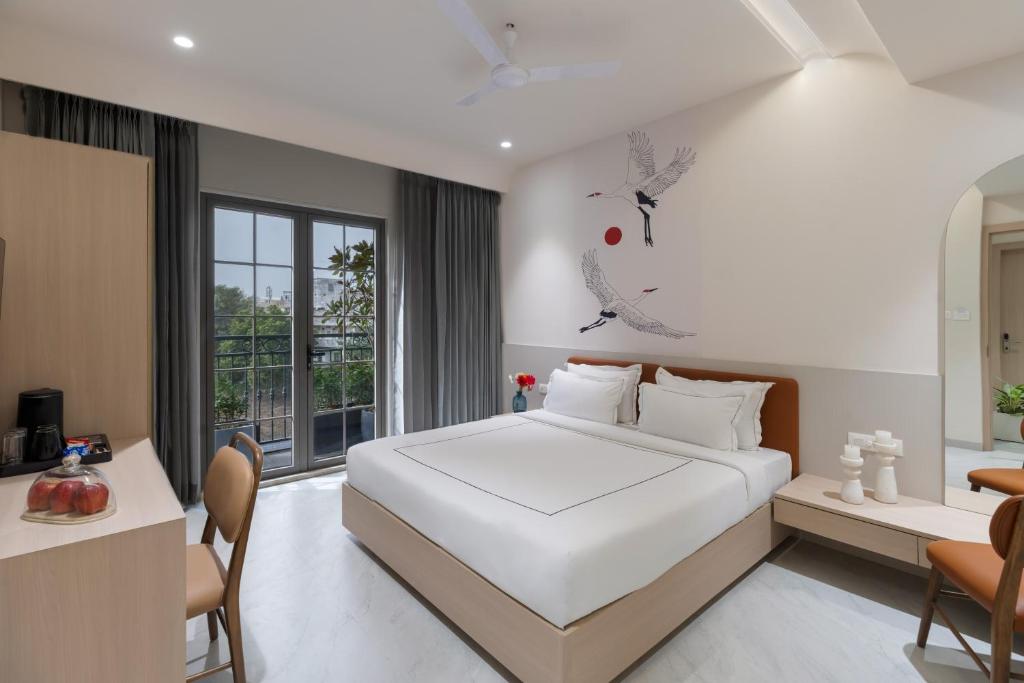 a bedroom with a large white bed and a desk at Champion Prime-My Downtown Hotel in Udaipur