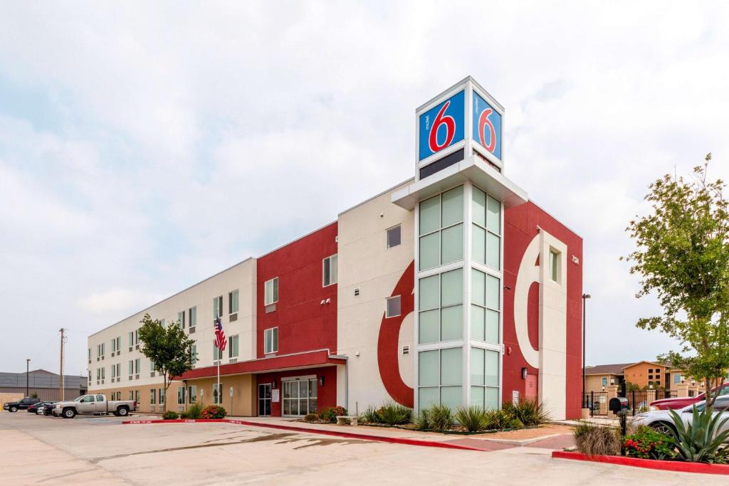 ein rotweißes Gebäude mit einem Uhrturm in der Unterkunft Motel 6-Laredo, TX - Airport in Laredo