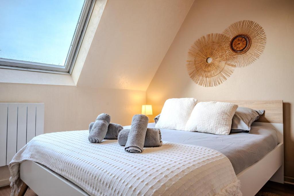 Un dormitorio con una cama con toallas. en Cocon Sous les Toits - Proche Centre Ville - Parking Gratuit - Commerces à Proximité, en Sélestat