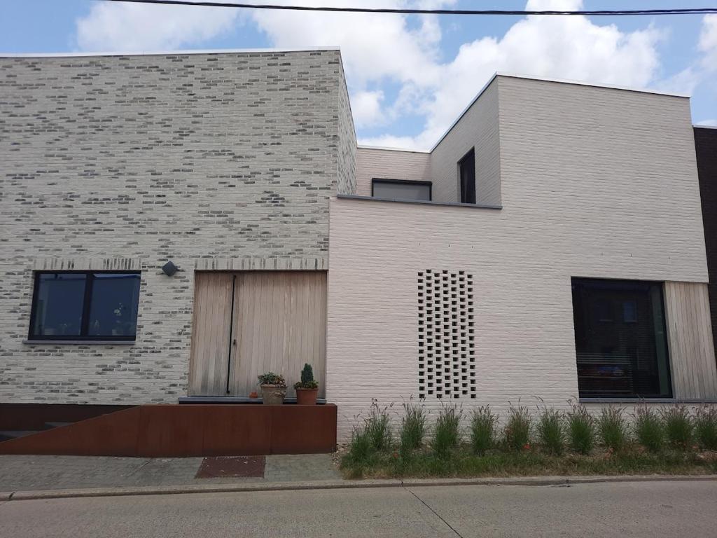 兰登Met een knipoog naar de fruitstreek!的白色砖屋,设有棕色的门