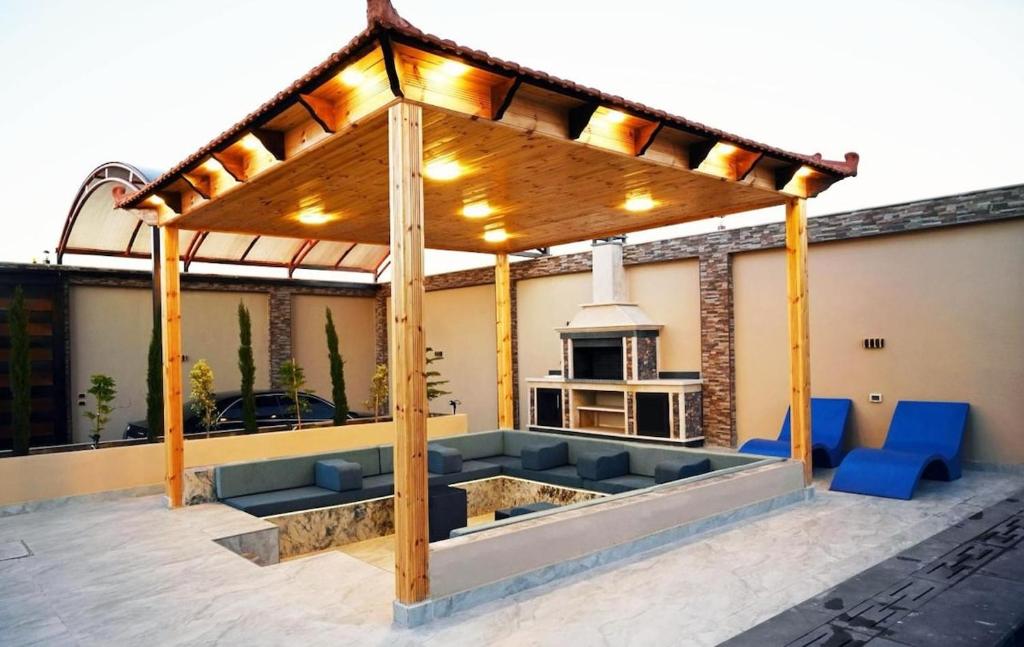 une pergola sur le toit d'une maison avec des chaises bleues dans l'établissement For daily, weekly monthly and yearly stays, à Amman