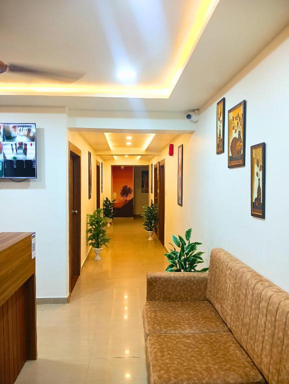 a living room with a couch and a hallway at Hotel Shree Maya Inn in Vadodara