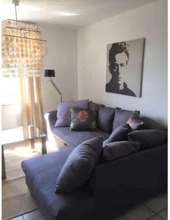 a living room with a blue couch and a window at Design Wohnung in Petersdorf auf Fehmarn