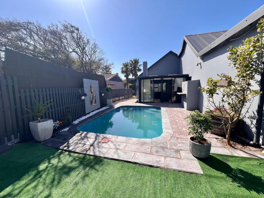 ein Schwimmbad in einem Hof neben einem Haus in der Unterkunft Blue Bay Villa in Saldanha