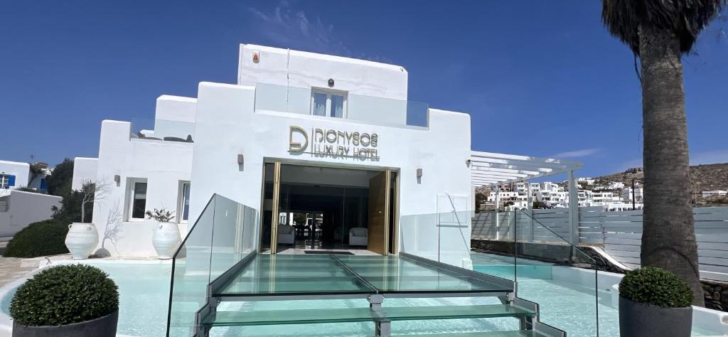 a building with a glass staircase in front of it at Dionysos Luxury Hotel Mykonos in Ornos