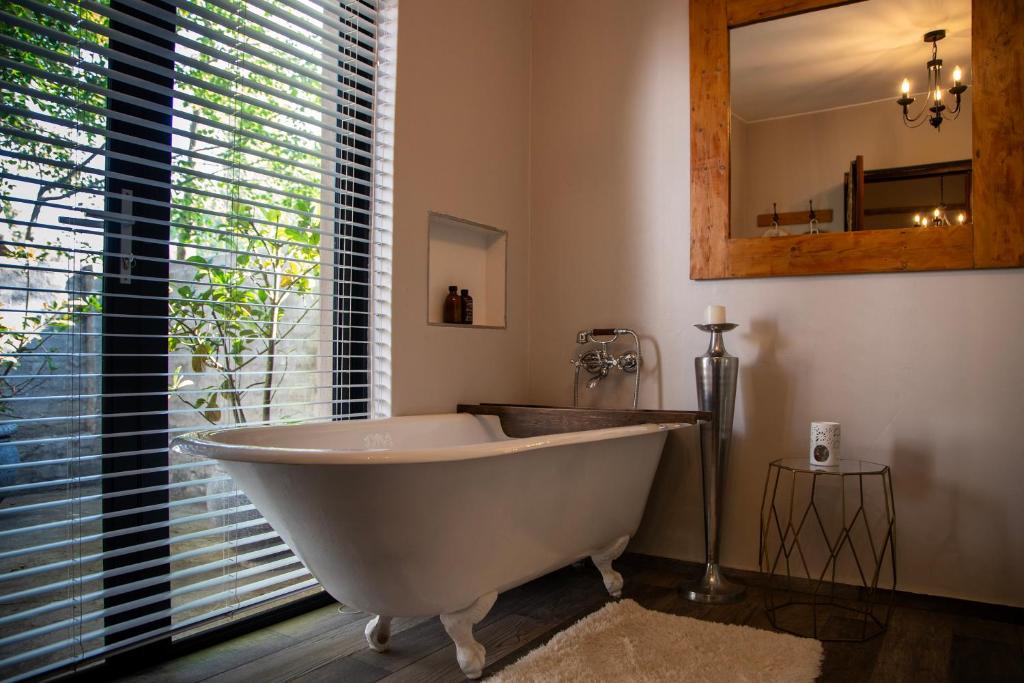 eine weiße Badewanne in einem Badezimmer mit Fenster in der Unterkunft Tarry-Stone Cottages in Dullstroom