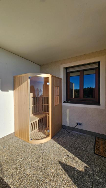 a large wooden enclosure in a room with a window at Apartment Wanderlust Gerlitzen in Kanzelhöhe