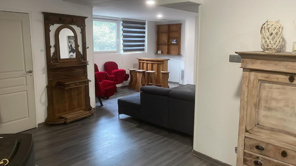 a living room with a couch and red chairs at Appartement dans un cadre bucolique in Charly-sur-Marne