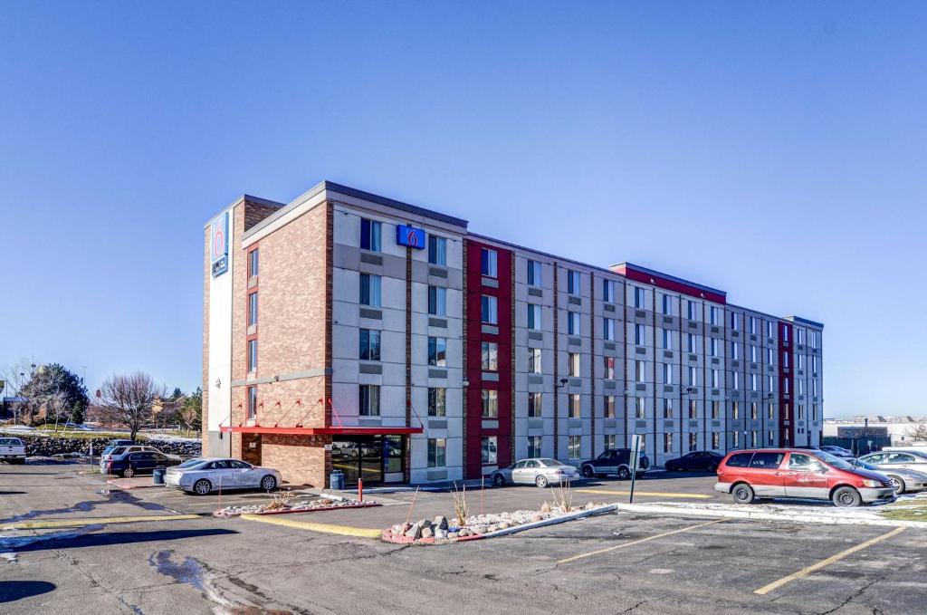 un gran edificio en un estacionamiento con coches aparcados en Motel 6-Greenwood Village, CO - Denver - South Tech Center, en Greenwood Village