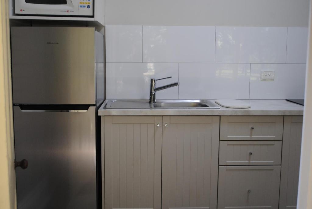 Schoolhouse的厨房配有水槽和不锈钢冰箱