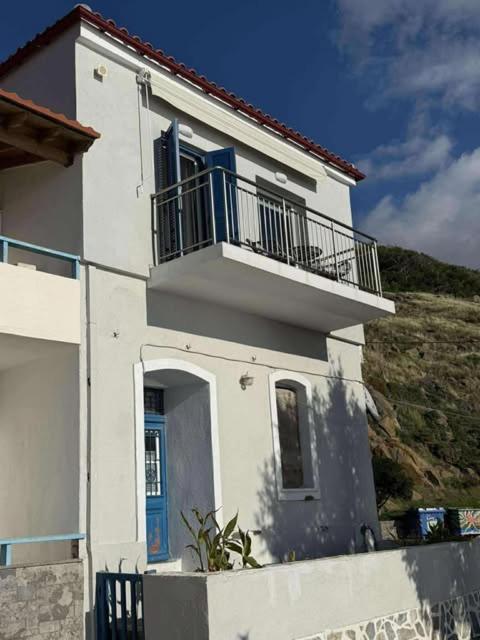 a white house with a balcony on top of it at Aegean View Apartment in Skala Eresou