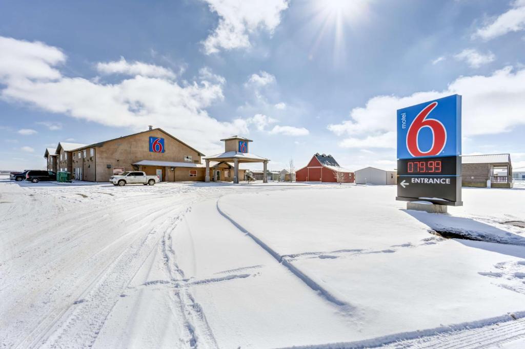 a sign in the snow in front of a building at Motel 6-Innisfail, AB in Innisfail